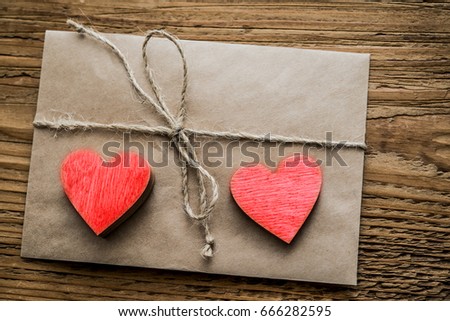 vintage retro brown Envelope with two red wooden hearts and ribbon With a node on a old wood board  background. empty copy space for inscription. happy Valentine's day idea, sign, symbol