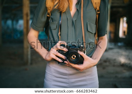 Close up of hipster woman taking photo with retro camera. Midsection of travel girl photographer