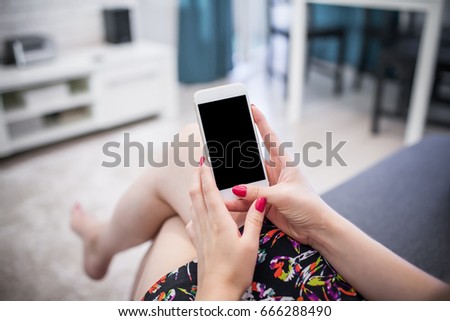 Young woman holding empty copy space white mobile phone in home.