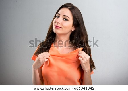 Beautiful young girl proud of herself on grey background
