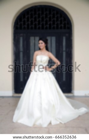 Blur style picture of wedding concept, Bride in Luxury bridal dress standing in front of curved door.