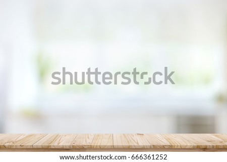Empty wood table top on blur kitchen window background. For product or foods montage.