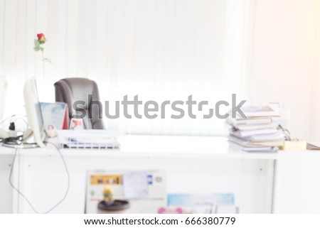 Blur background of modern office interior building, Supervisor office table near window, computer and flower. View from above with copy space