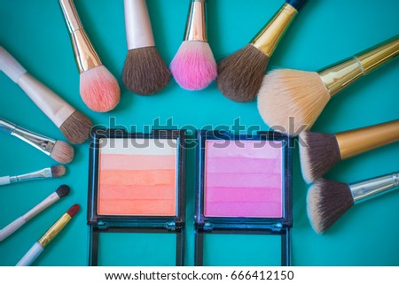 Set of decorative cosmetics and brushes on Green background.