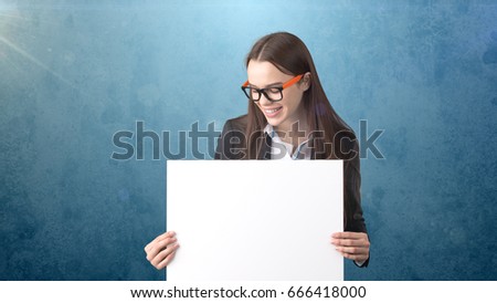 Smile Business woman portrait with blank white board on blue isolated . Female model with long hair in glasses.