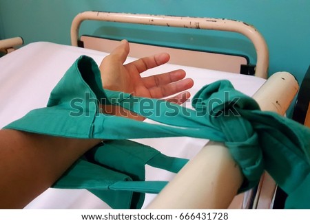 Close up image of patient hand restraint on hospital bed. Royalty-Free Stock Photo #666431728