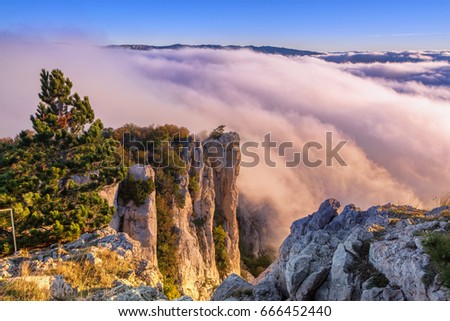 Ocean of a cloud and sky of dawn. Crimea. Mountain Ay-Petri. Mountain cloudy landscape. Crimean landscape. Clouds are painted by flowers of dawn. Mountain top Royalty-Free Stock Photo #666452440