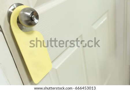 yellow hanging door sign on the door knob 