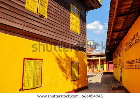 Wat Si Muang ,Laos ,shadow on the wall ,red wall ,yellow wall background, blue sky
