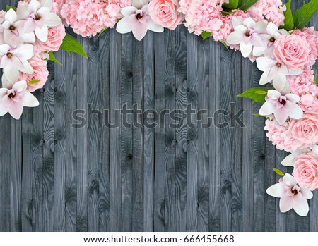 Magnolia flowers with roses, hortensia and place for your text on background of shabby wooden planks in rustic style. Top view. Flat design. Copy space.