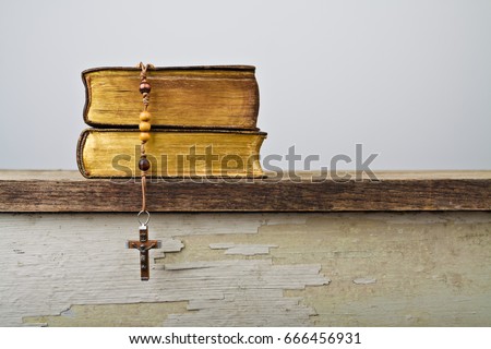 The book of Catholic Church liturgy and rosary beads on the wooden table Royalty-Free Stock Photo #666456931