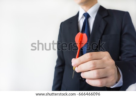 Businessman holding a dart  - business targeting, aiming, focus concept.