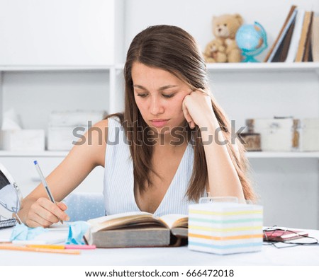 Student girl is reading text at home.