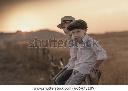 Boys sit on a wooden fence