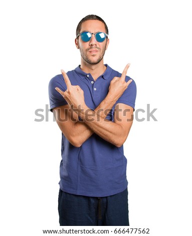Naughty young man with rock gesture on white background