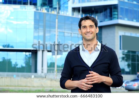 Confident happy men entrepreneur enjoying calm after hard work day. Portrait of a young successful business man thinking about something on the background of an office building. Royalty-Free Stock Photo #666483100