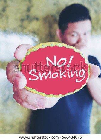 Young man is showing no smoking label