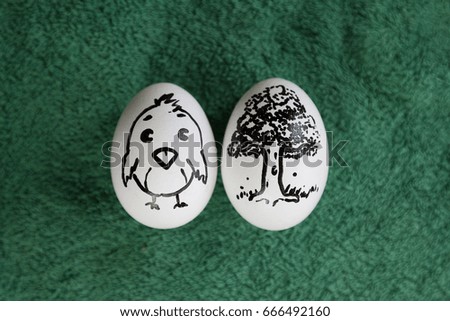 Two eggs with drawn chicken and tree
