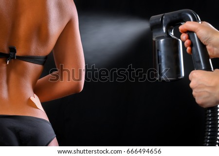 Woman body paint with airbrush in professional beauty salon Royalty-Free Stock Photo #666494656