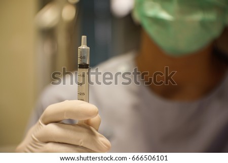 Female doctor hand holding syringe 