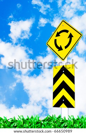 traffic circle road sign on beautiful sky and grass field background
