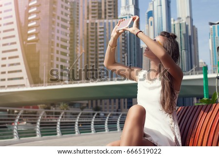 Tourist taking travel picture with phone of Dubai marina and city skyline. Summer luxury holidays.