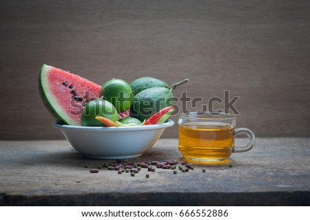 Tea break, paired on fruit and vegetables on wooden background with Still life