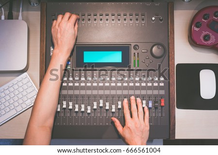 sound engineer hands working on digital sound mixer, music recording concept