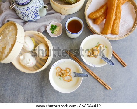 A typical Chinese family breakfast of market food / Chinese Home Breakfast / 
 Home boiled rice congee with beancurd skin boils till dissolved,salt,ginger,scallions eaten with fried fritters youtiao
