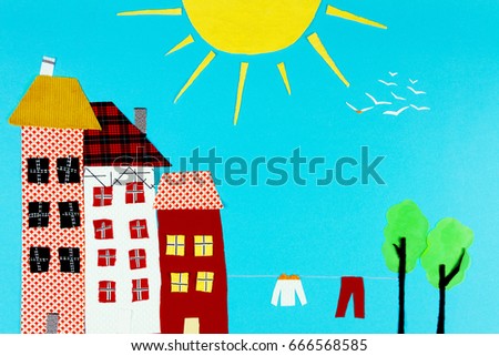 Fabric town. Houses, the sun made of colorful pieces of fabric isolated on blue background. 