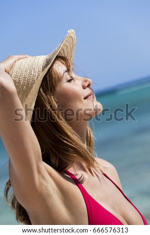Portrait of a beautiful woman in profile on the sea with a straw hat