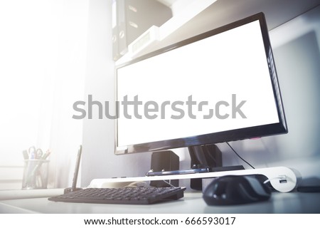 Desktop computer on desk in home office interior, empty screen 