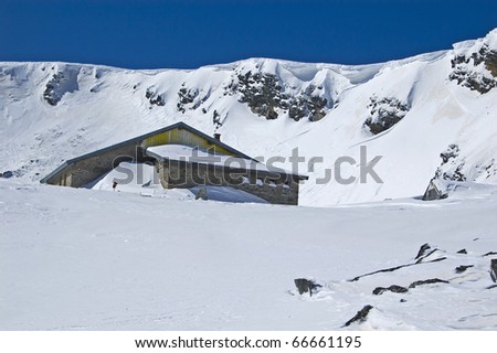 Mountain house in the snow at sunny day
