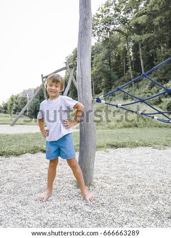 Blond boy playing on a children‘s playground and has fun