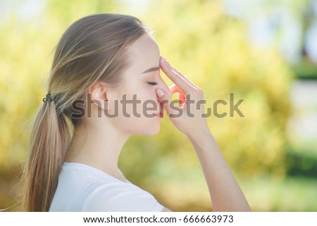 Portrait of beautiful young woman doing yoga exercises, using pranayama technique. Close up. View from the right side Royalty-Free Stock Photo #666663973