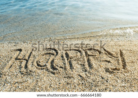 Word Happy written on the beach sand