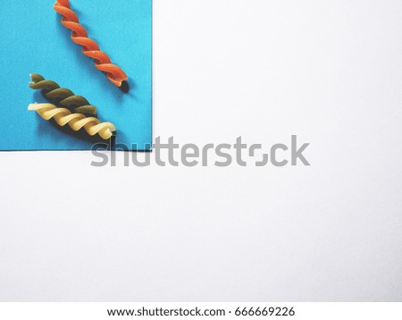 It's time to cook, The picture of multicolored of dried fusilli consist of yellow, orange and green on white background.  soft tone color