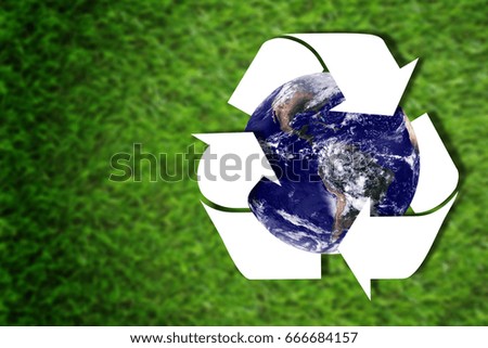 The earth and white recycle symbol on green grass background, ecology concept, Elements of this image furnished by NASA