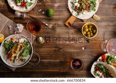 Tacos with fried avocados , tomatoes and greens on distressed wooden background. Served with beer, lime and olives. Mexican cuisine interpretation. Horizontal composition with copy space.