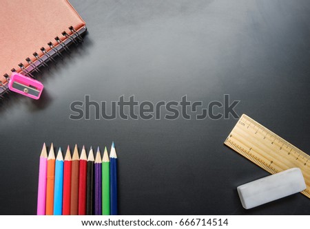 top view image Stationary set for working and study of student is colored Pencil Sets,red Leather Notebook Cover,pencil sharpener,wooden ruler and white eraser on the dark table and copy space.