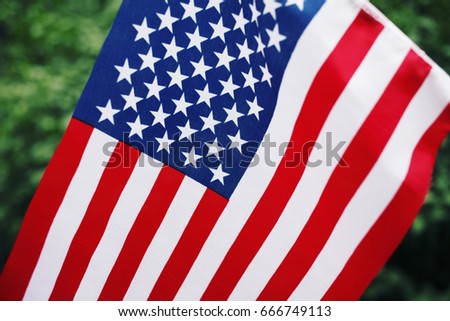 Hand holding the Flag of USA. Fourth of July Independence Day, Patriotic holiday, American flag.