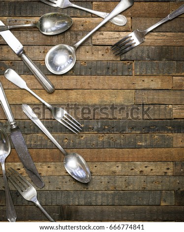 Vintage antique spoons, forks and knives on old wooden background flat lay food blog mockup, copy space