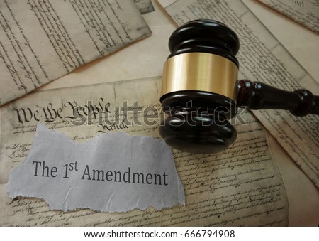 First Amendment news headline on a copy of the US Constitution with gavel                             Royalty-Free Stock Photo #666794908
