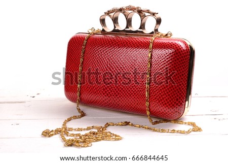 Red wallet purse with brass knuckles on white background.