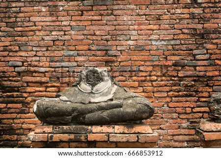 Broken statue in a temple at  Ayutthaya,Thailand (Old brick background)