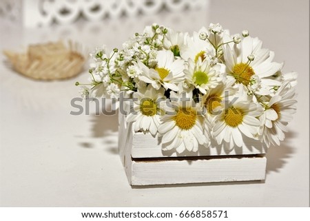 White chrysanthemums in the white box and small straw hat