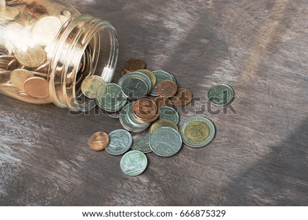 Baht coin spill form the bottle on wooden background,Save little by little