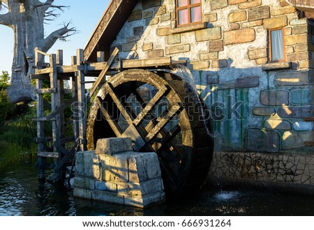 Fabulous house and the wheel that turns the water and gives energy Royalty-Free Stock Photo #666931264