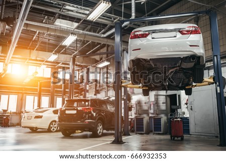 Car raised on car lift in autoservice. Royalty-Free Stock Photo #666932353