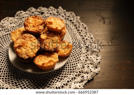 Beautiful muffins on a dark wooden background. Vignetting and darkening on the background, light on sweets.